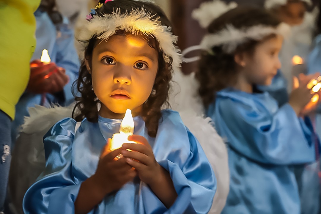 Foto de Criança vestida de anjo com vela na mão