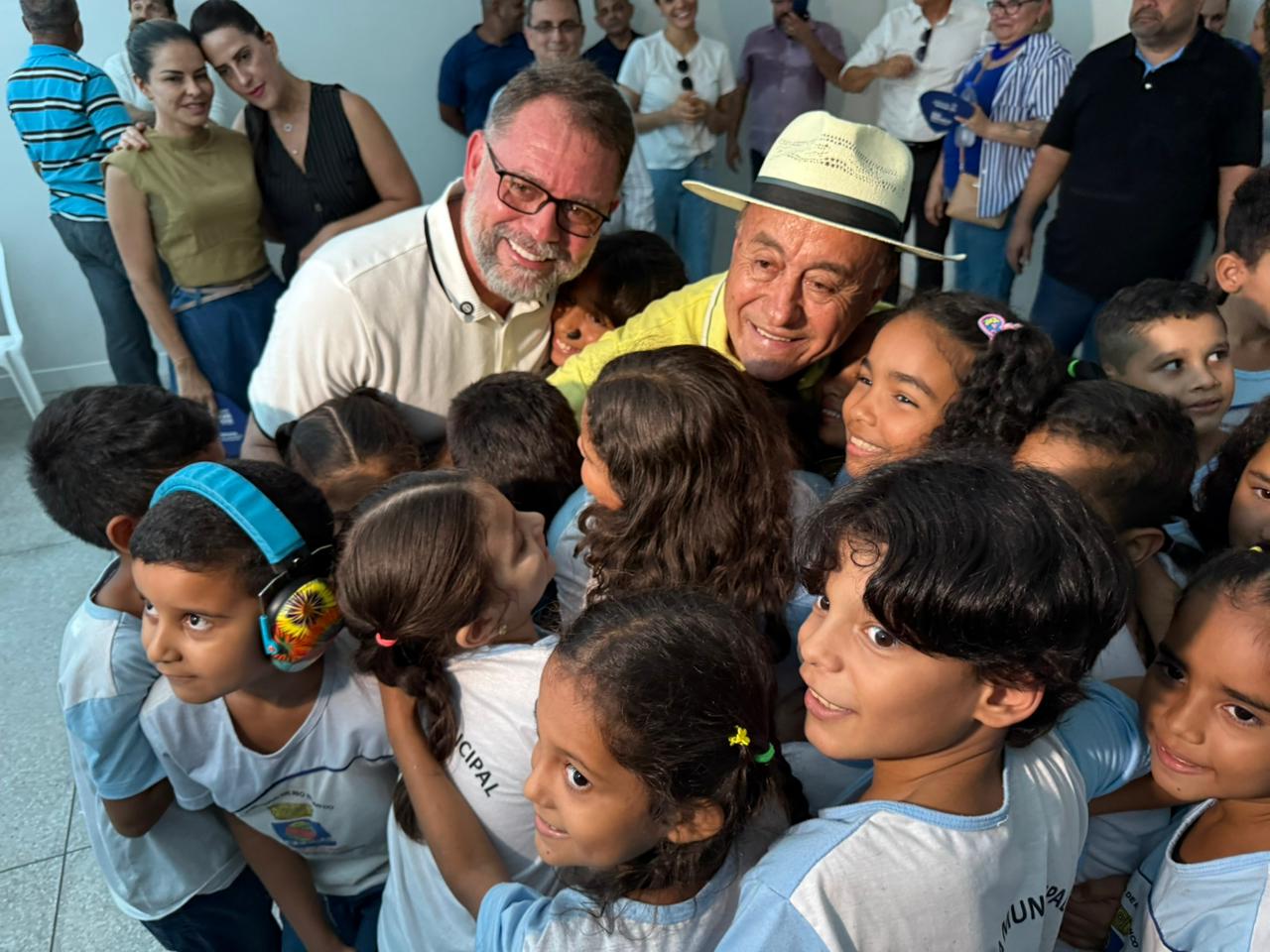 Foto dos alunos abraçando os prefeitos